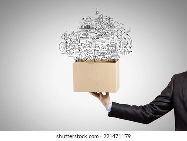 Man holding carton box with business sketches