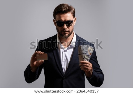 Man holding cash money in dollar banknotes on gray. Studio portrait of businessman with bunch of dollar banknotes. Dollar money concept. Career wealth business. Cash dollar banner.