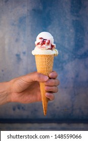 Man Holding Cherry Ice Cream In Wafer Cone