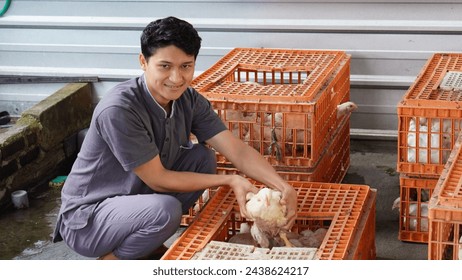 A man was holding a chicken in the cage with joy - Powered by Shutterstock