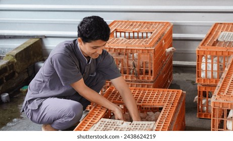 A man was holding a chicken in the cage with joy - Powered by Shutterstock