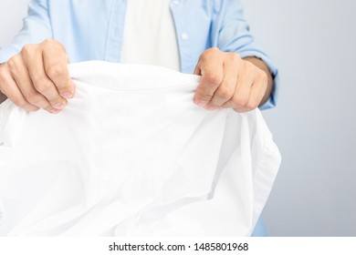 Man Holding Clean Shirt, Man's Hands With White Shirt, Close Up, Cropped Image, Copy Space, Toned