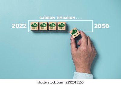 Man holding CO2 reducing icon with virtual loading for decrease CO2 , carbon footprint and carbon credit to limit global warming from climate change, Kyoto2050 protocol. - Shutterstock ID 2232013155