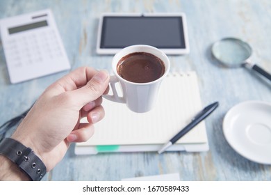 Man Holding Coffee Cup In Office Desk.