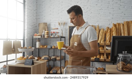 Man holding coffee cup and smartphone in bakery filled with bread and pastries indoors - Powered by Shutterstock