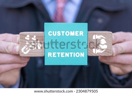 Man holding colorful blocks with icons and inscription: CUSTOMER RETENTION. Concept of customer acquisition and retention business marketing. Incentive and welfare program. Retain clients.