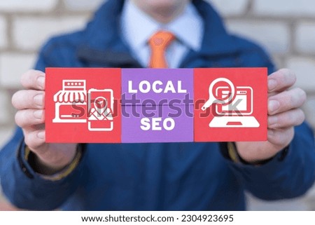 Man holding colorful blocks with icons and inscription: LOCAL SEO. Local search marketing e-commerce. Concept of local seo strategy, local search optimization.