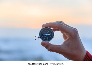 Man Holding Compass In Snow Road
