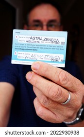 Man Holding Up A Coronavirus Vaccination Card Showing Both Stamps Of The Astra Zeneca Vaccine With Soft Focus Background. Boston Lincs. UK . Aug 2021