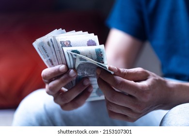 man holding and counting Egyptian currency  - Shutterstock ID 2153107301
