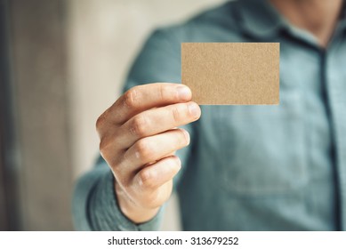 Man Holding Craft Business Card On Concrete Wall Background