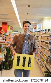 Man Holding Crate Of Beer In An Organic Grocery Store