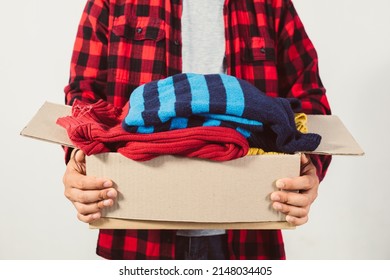 man holding a crate of second-hand clothes unused clothes - Shutterstock ID 2148034405