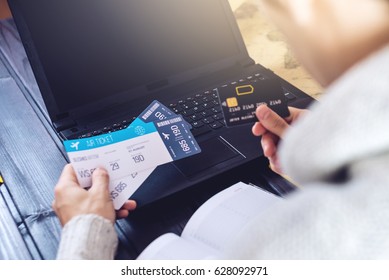 Man Holding A Credit Card And Buys Plane Tickets On The Internet Working On The Laptop. The Concept Of Travel And Transport, Buying And Booking