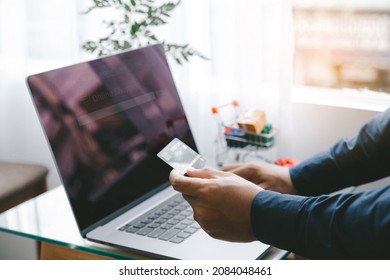 Man Holding credit card and using a laptop with shopping online to buy a gift for girlfriend at the cafe. Black Friday and shopping online Concept.  - Shutterstock ID 2084048461