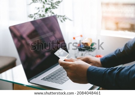 Man Holding credit card and using a laptop with shopping online to buy a gift for girlfriend at the cafe. Black Friday and shopping online Concept. 