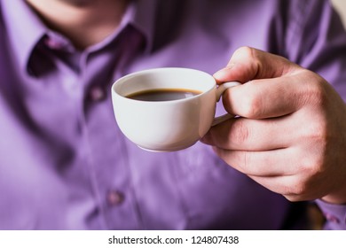 A man holding a cup of coffee - Powered by Shutterstock