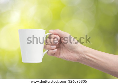 Similar – Foto Bild Frau Hand, die eine Tasse Kaffee von einem Holztisch im Garten aufzieht.