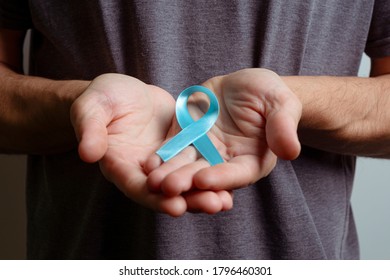 Man Holding Cyan Ribbon. Awareness Ribbon.