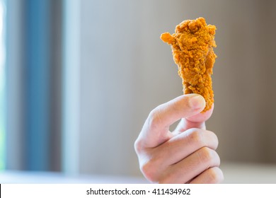 man is holding deep fried chicken drumstick with bure background