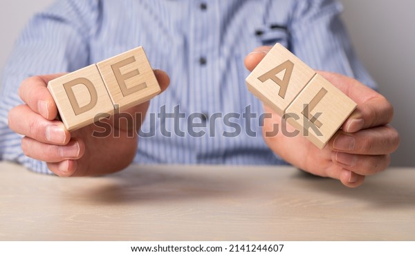Man\
holding divided blocks of word deal. Breaking contract, refusal to\
renew agreement. Anticipatory repudiation act. End of cooperation.\
Violation of conditions and rules. High quality\
photo
