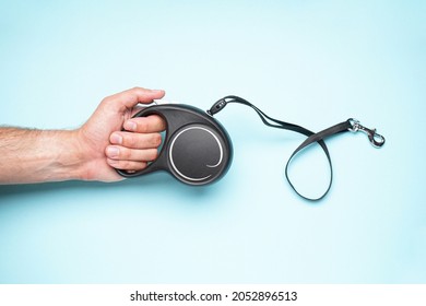 A Man Holding Dog Leash In Hand On A Blue Background.