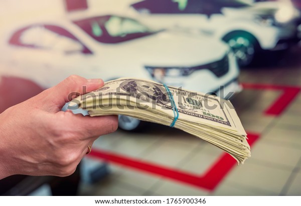 Man holding dollars for rent or buy car as\
background. business\
concept