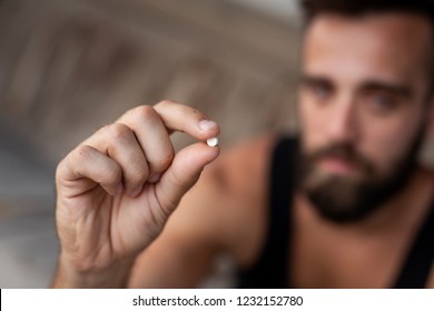 Man Holding An Ecstasy Pill. Focus On The Pill