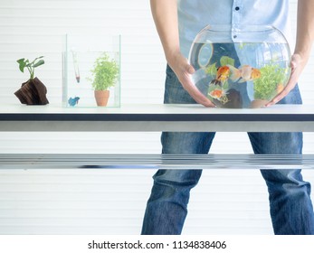 Man Holding Fish Bowl Tank