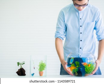 Man Holding Fish Bowl Tank.