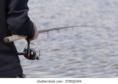 Man Holding Fishing Rod With Reel