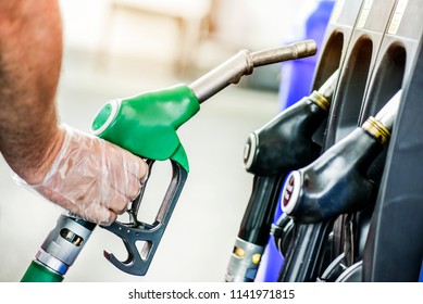 Man Is Holding A Gasoline Fuel Pistol At Gas Station. 