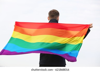 Man Holding Gay Flag On Light Background