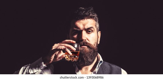 Man Holding A Glass Of Whisky. Sipping Whiskey. Portrait Of Man With Thick Beard. Macho Drinking. Degustation, Tasting. Man With Beard Holds Glass Brandy. Bearded Drink Cognac. Sommelier Tastes Drink.