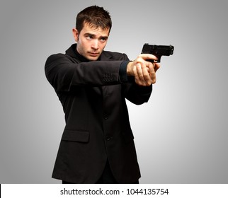 Man Holding Gun against a grey background
