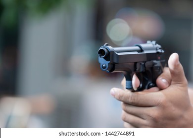 Man Holding Gun Aiming Pistol In Hand Ready To Shoot. The Criminal Robber Or Gangster Thief  Concept