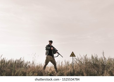  Man Holding Gun Near Toxic Symbol In Field, Post Apocalyptic Concept