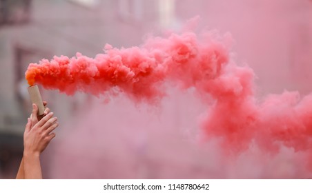 A Man Holding A Hand Flare With Red Smoke.