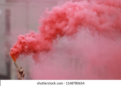 A Man Holding A Hand Flare With Red Smoke.