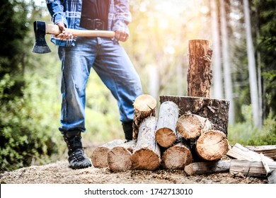 Man holding heavy ax. Axe in strong lumberjack hands chopping or cutting wood trunks .  - Powered by Shutterstock