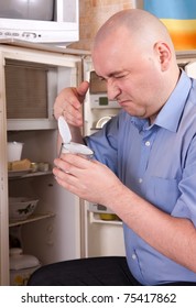  Man Holding Her Nose Because Of Bad Smell From Food Near Refrigerator  At Home