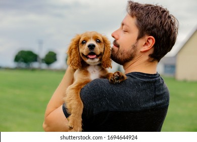 Man Holding His Cocker Spaniel Puppy Outside