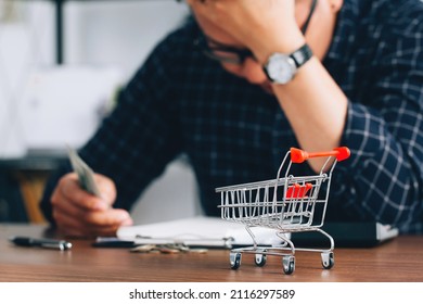 Man holding his forehead while having headache due to higher food prices from inflation.Rising food and grocery store prices and expensive daily consumer goods concept. The problem of inflation - Shutterstock ID 2116297589
