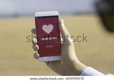 Man holding his mobile phone on the beach and using online dating app