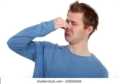 Man Holding His Nose Against A Bad Smell