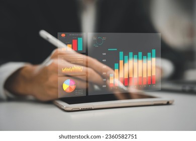 A man holding holographic graphs and stock market statistics gain profits. Concept of growth planning and business strategy. Corporate strategy for finance, operations, sales, marketing.
