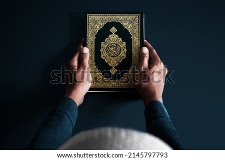 Man holding holy book on dark background
