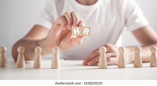 Man holding HR word on wooden cubes. Human Resources - Shutterstock ID 1558220210