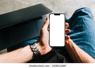 Man Holding IPhone 13 Pro With A White Screen Mock Up While Sitting On A Sofa. Rostov-on-Don, Russia - November 1 2021