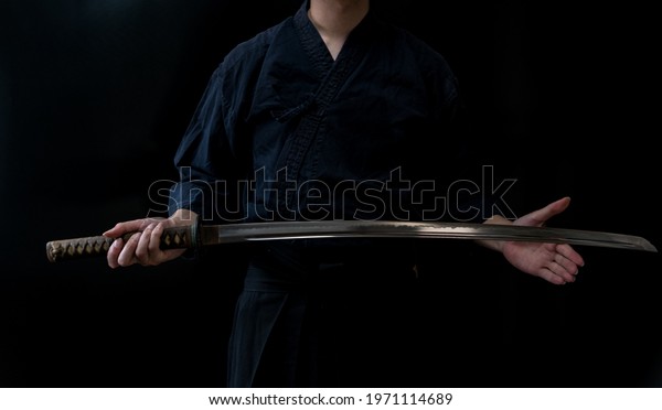 A man holding Japanese\
sword